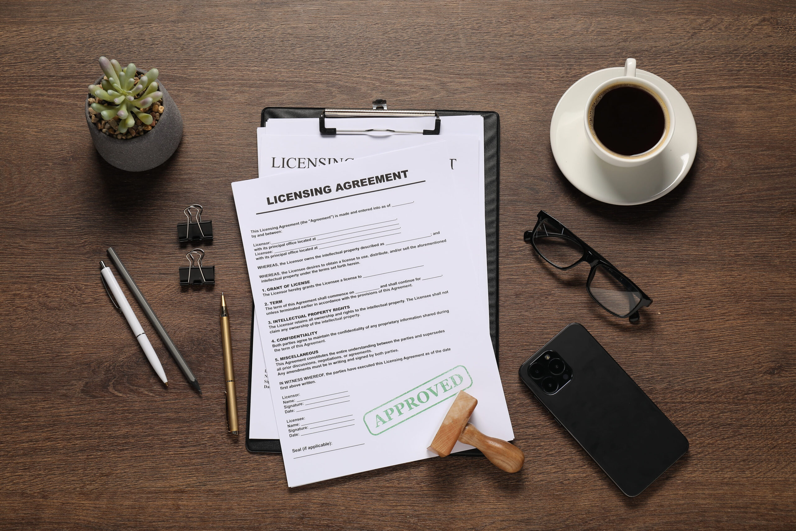 flat lay composition with licensing agreement documents on wooden table